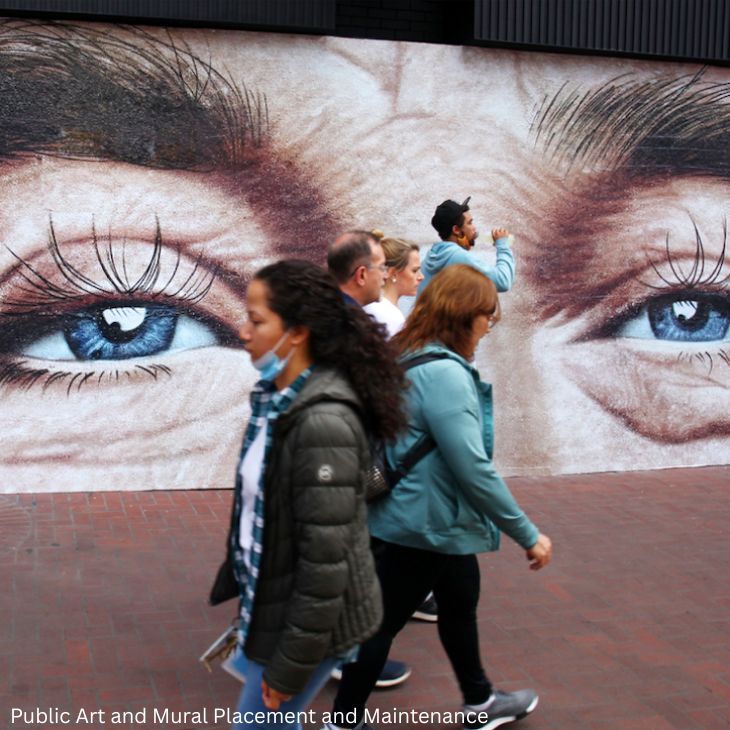 people walking by mural